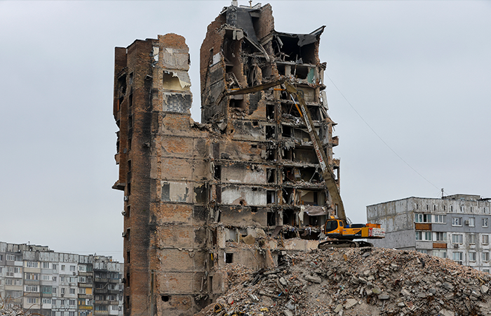 An xcavator demolishes a multi-storey apartment block, which was destroyed in the course of Russia-Ukraine conflict, in Mariupol, Russian-controlled Ukraine, March 16, 2023. REUTERS