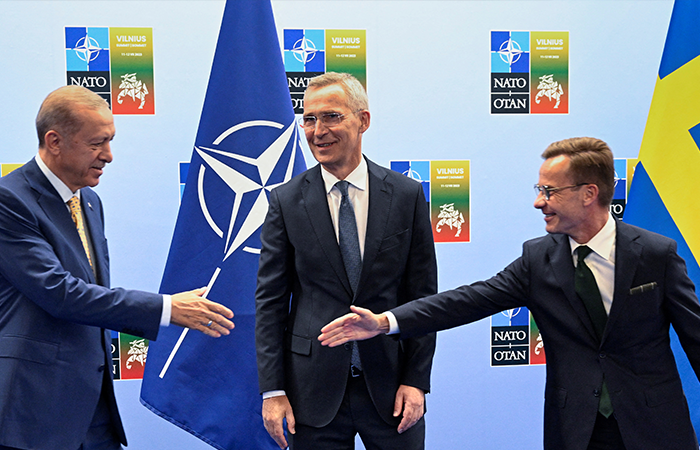 Turkish President Tayyip Erdogan and Swedish Prime Minister Ulf Kristersson shake hands next to NATO Secretary-General Jens Stoltenberg prior to their meeting, on the eve of a NATO summit, in Vilnius, Lithuania July 10, 2023