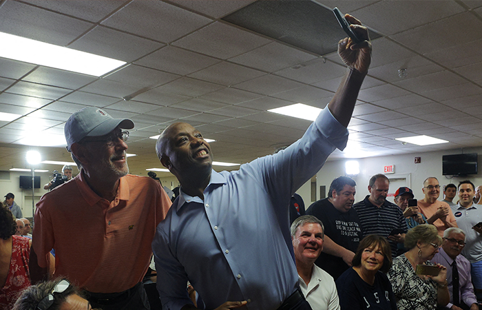 Republican presidential candidate U.S. Senator Tim Scott (R-SC) poses for a selfie with an audience member at a campaign town hall meeting in Salem, New Hampshire, U.S., July 18, 2023. REUTERS